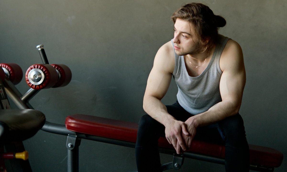 man sitting on bench with dumbbells