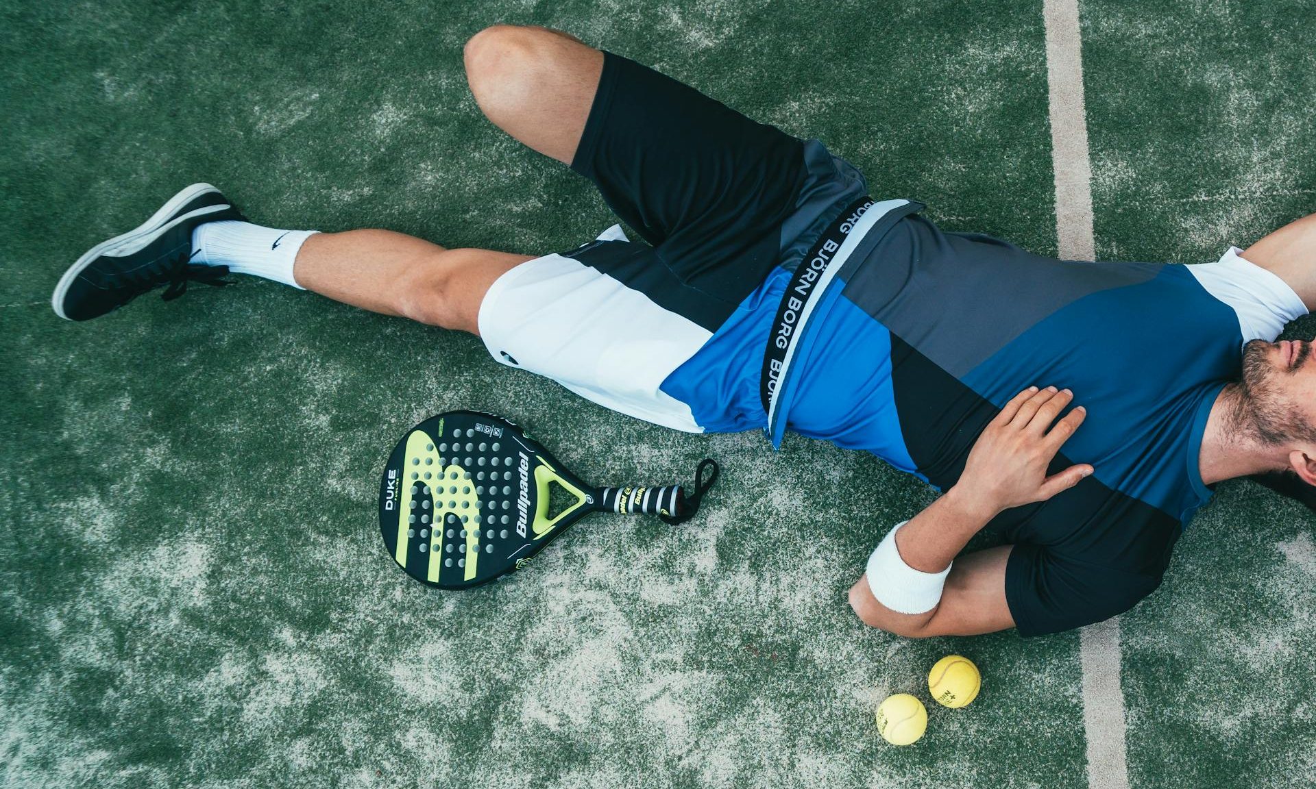 man laying on floor padel sport