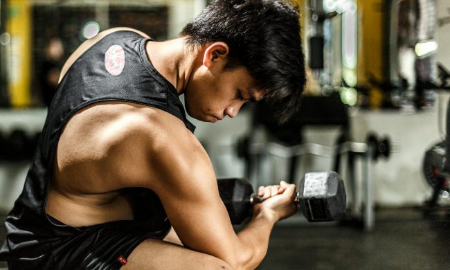 man doing bicep curl concentration curl