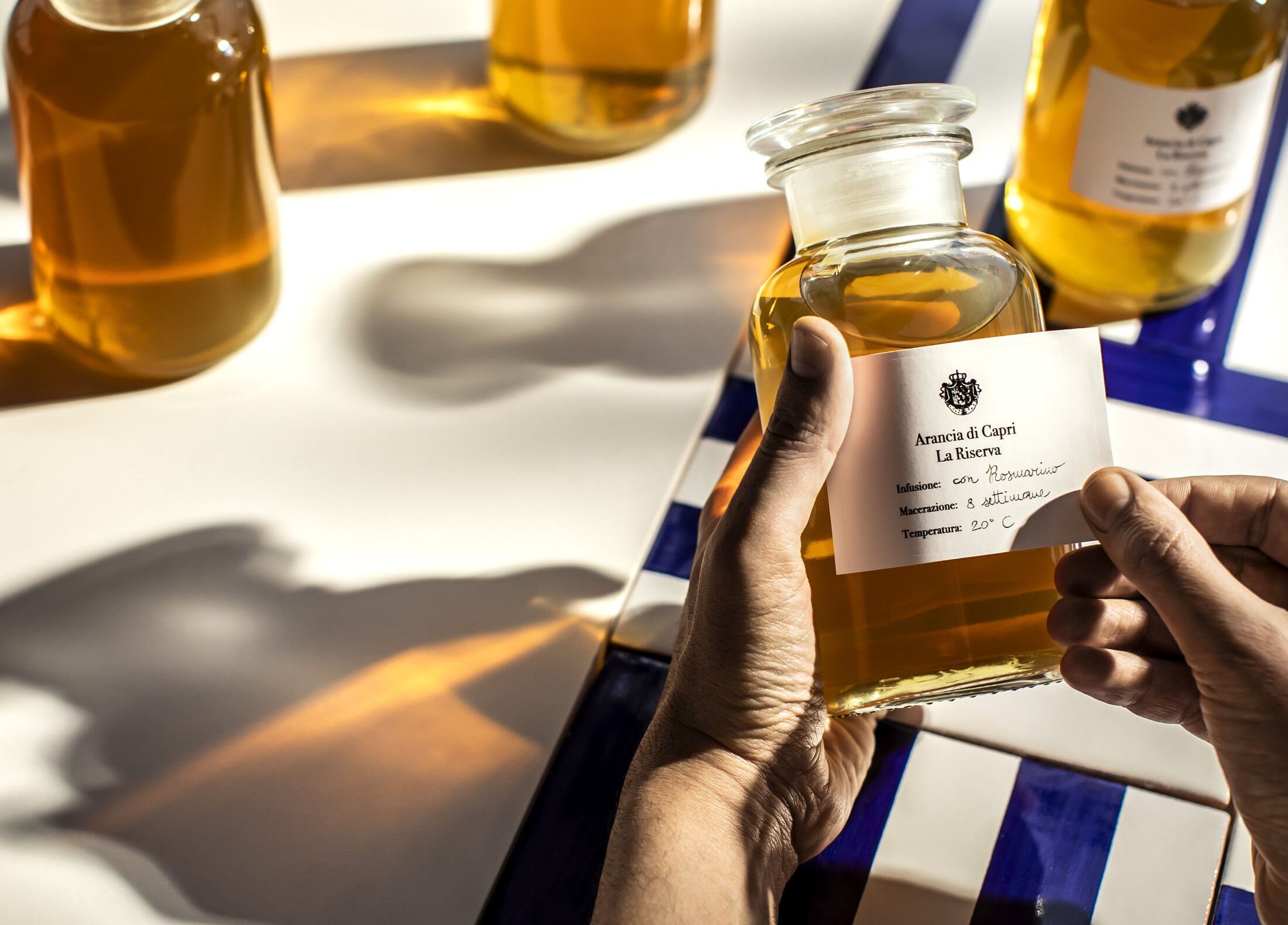 man putting label on acqua di parma bottle