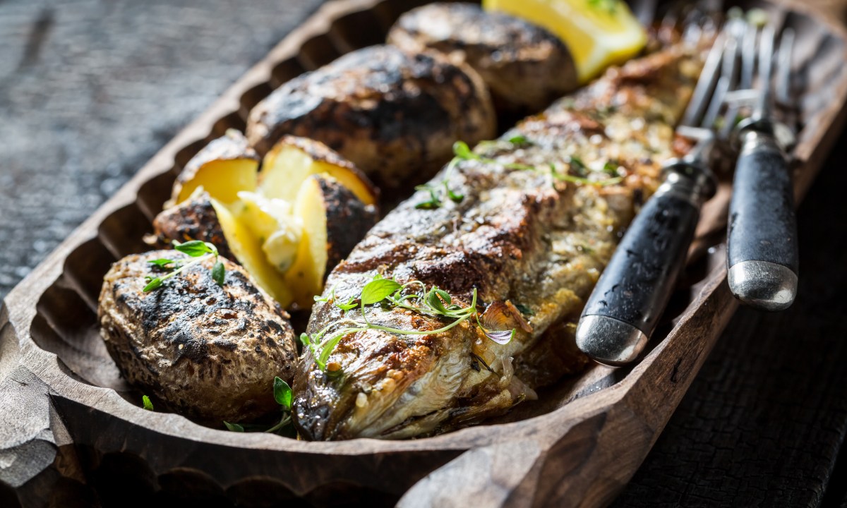 Homemade potatoes and trout fish with herbs and butter