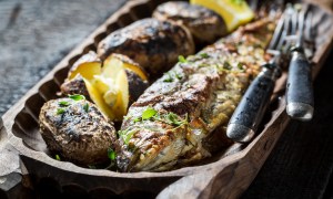 Homemade potatoes and trout fish with herbs and butter