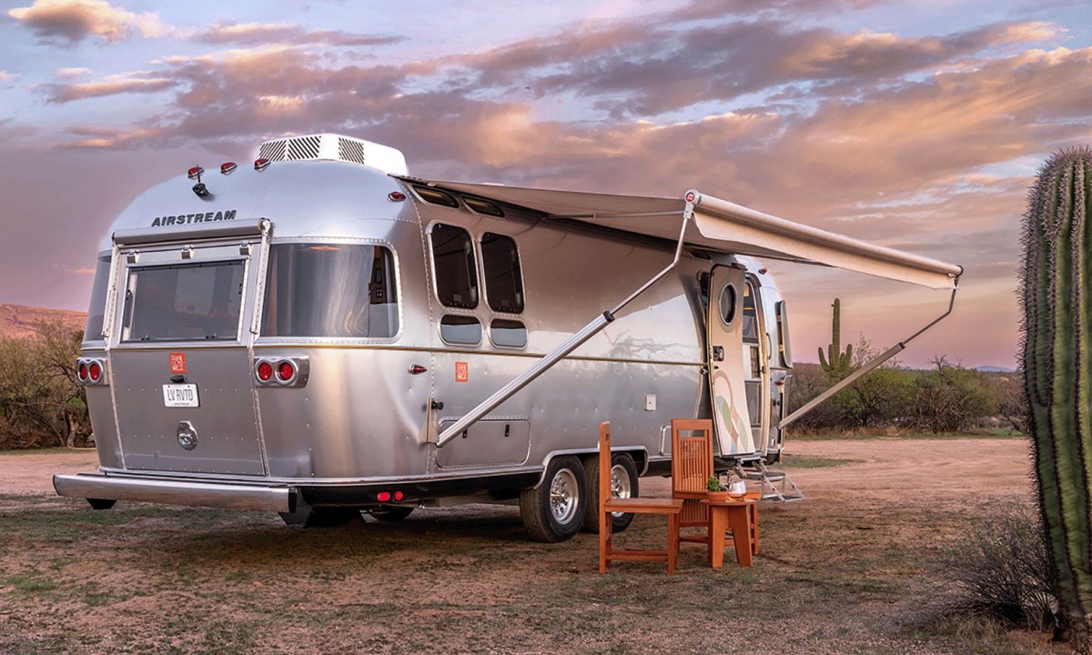 Exterior of the all-new Airstream Frank Lloyd Wright Usonian Limited Edition Travel Trailer parked in the desert at sunset.