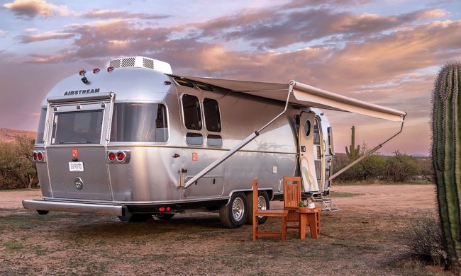 An Airstream Frank Lloyd Wright Usonian Limited Edition Travel Trailer parked in the desert.