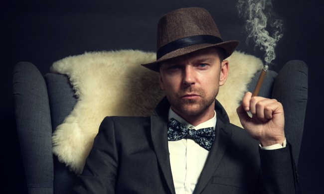 well-dressed guy smoking on a couch in the dark