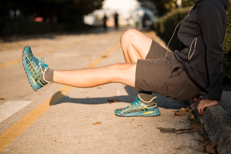 Man stretching and wearing running shoes.