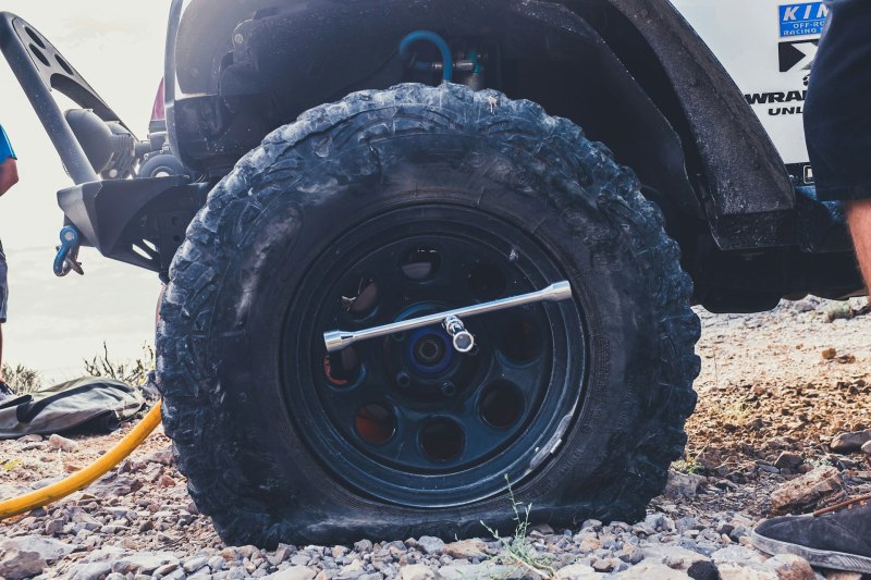 Closeup of a flat tire on a white Jeep Wrangler Unlimited.