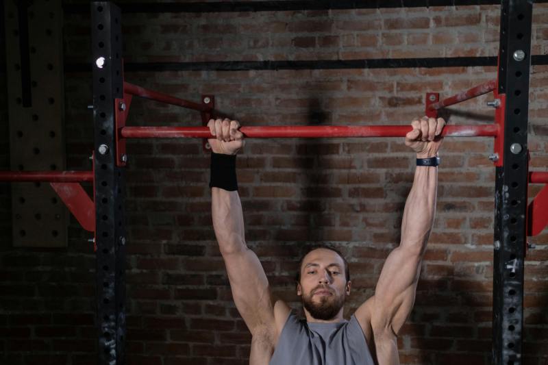 Man hanging from pull up bar.