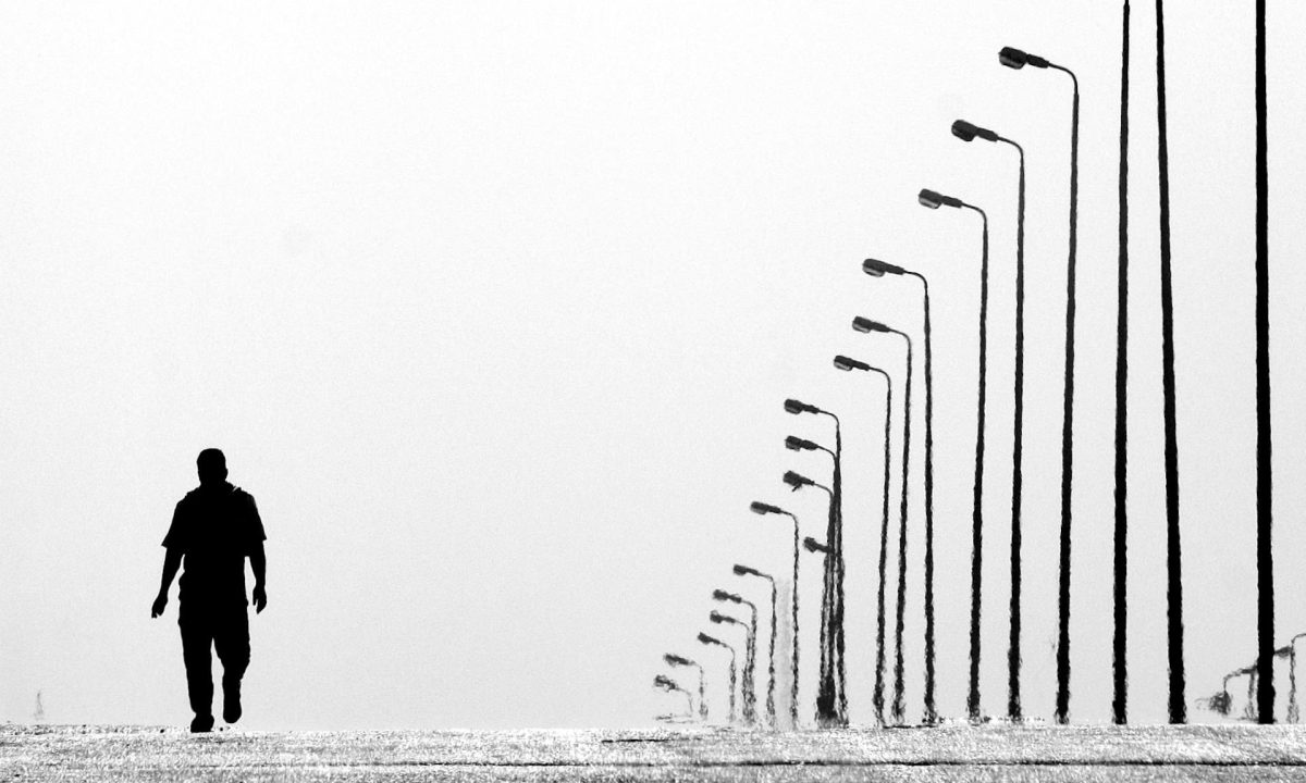 man walking near streetlights