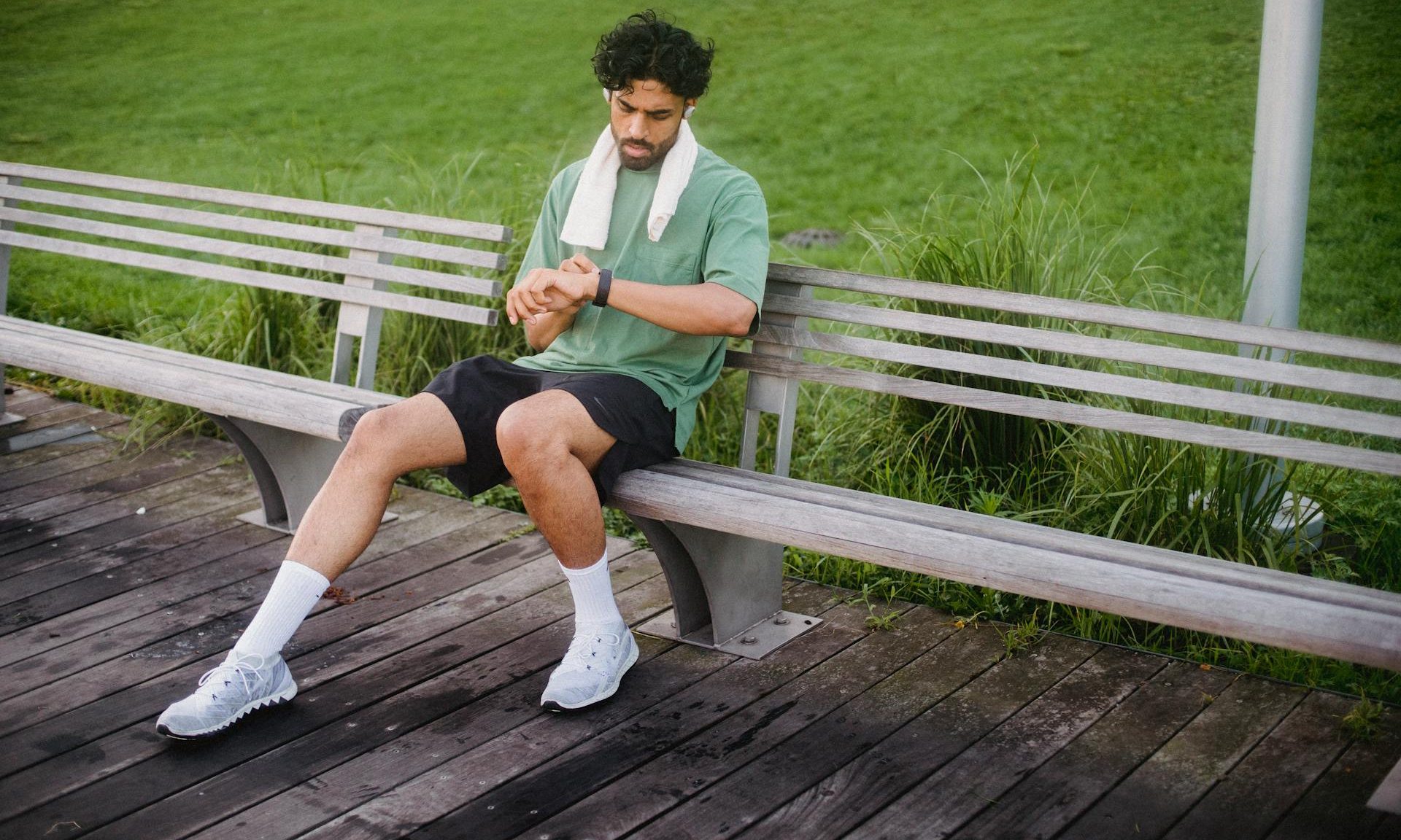man sitting on bench outside checking fitness tracker Apple Watch