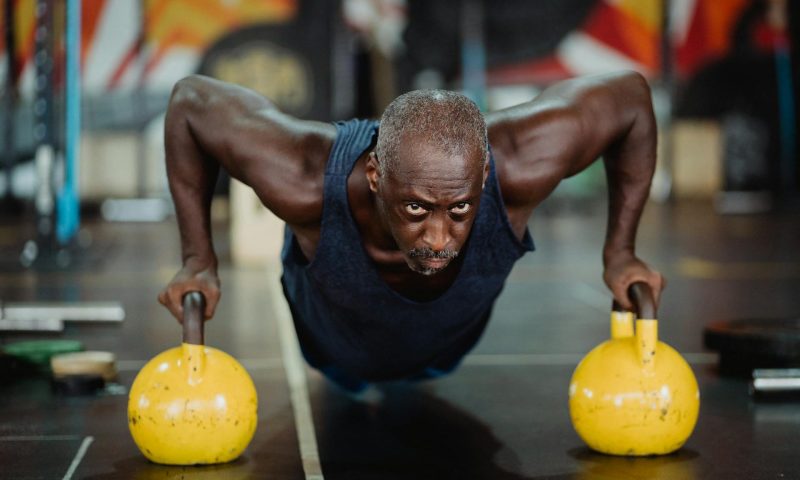 man with kettlebells push up renegade row
