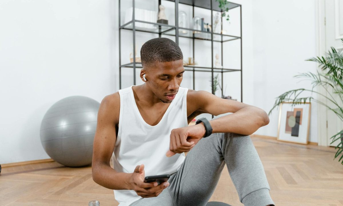 man sitting checking Apple Watch fitness tracker