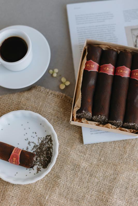cigars in ashtray next to cup of coffee