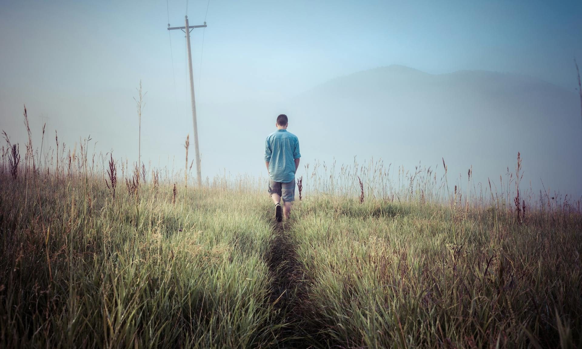 man walking in meadows in grass