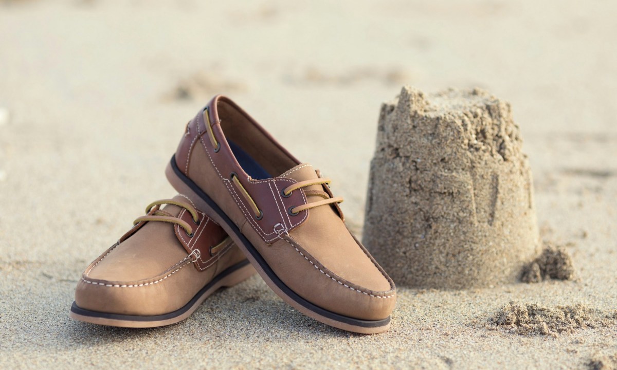 pair of boat shoes in sand