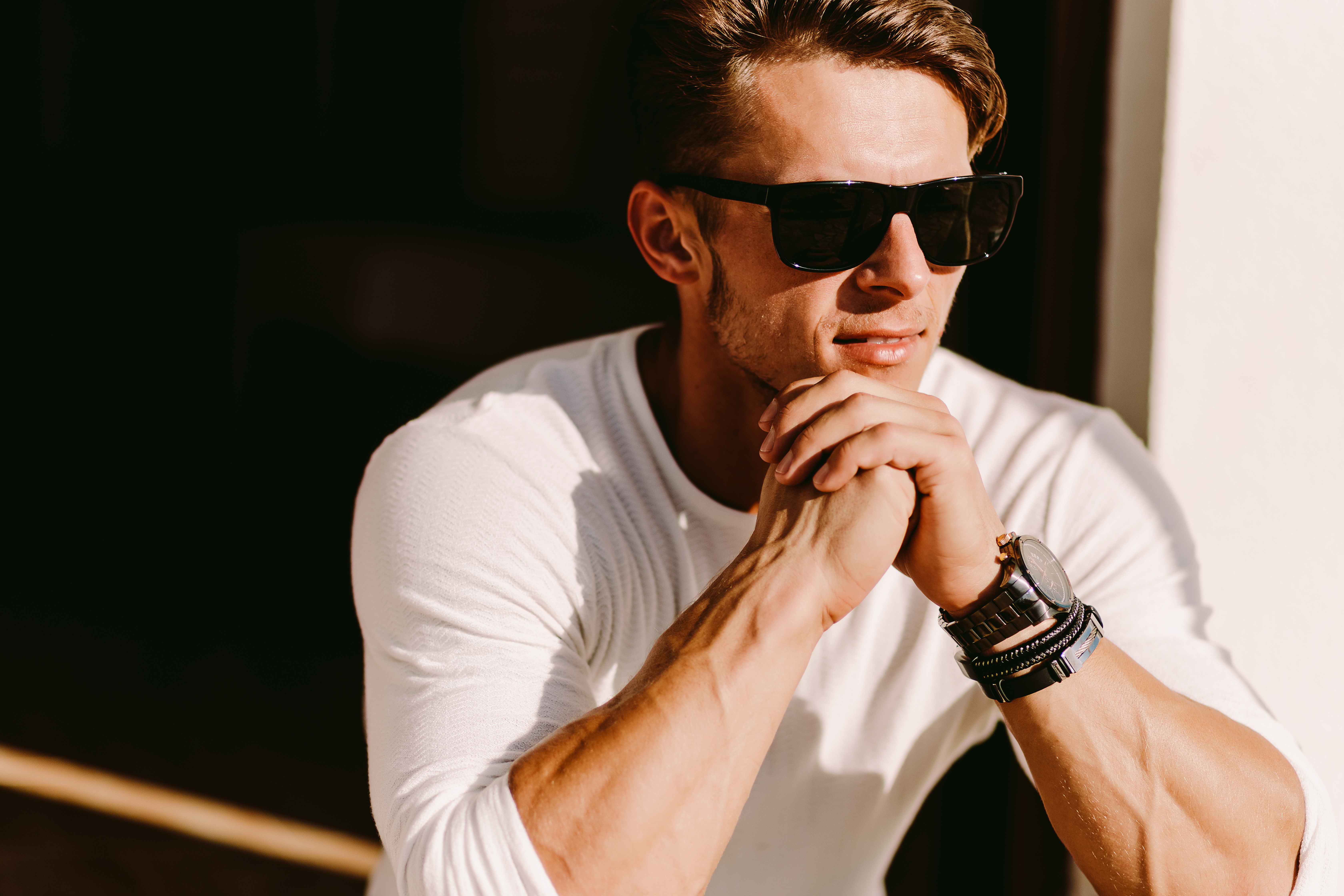 portrait of a handsome man in sunglasses and watch outdoors.
