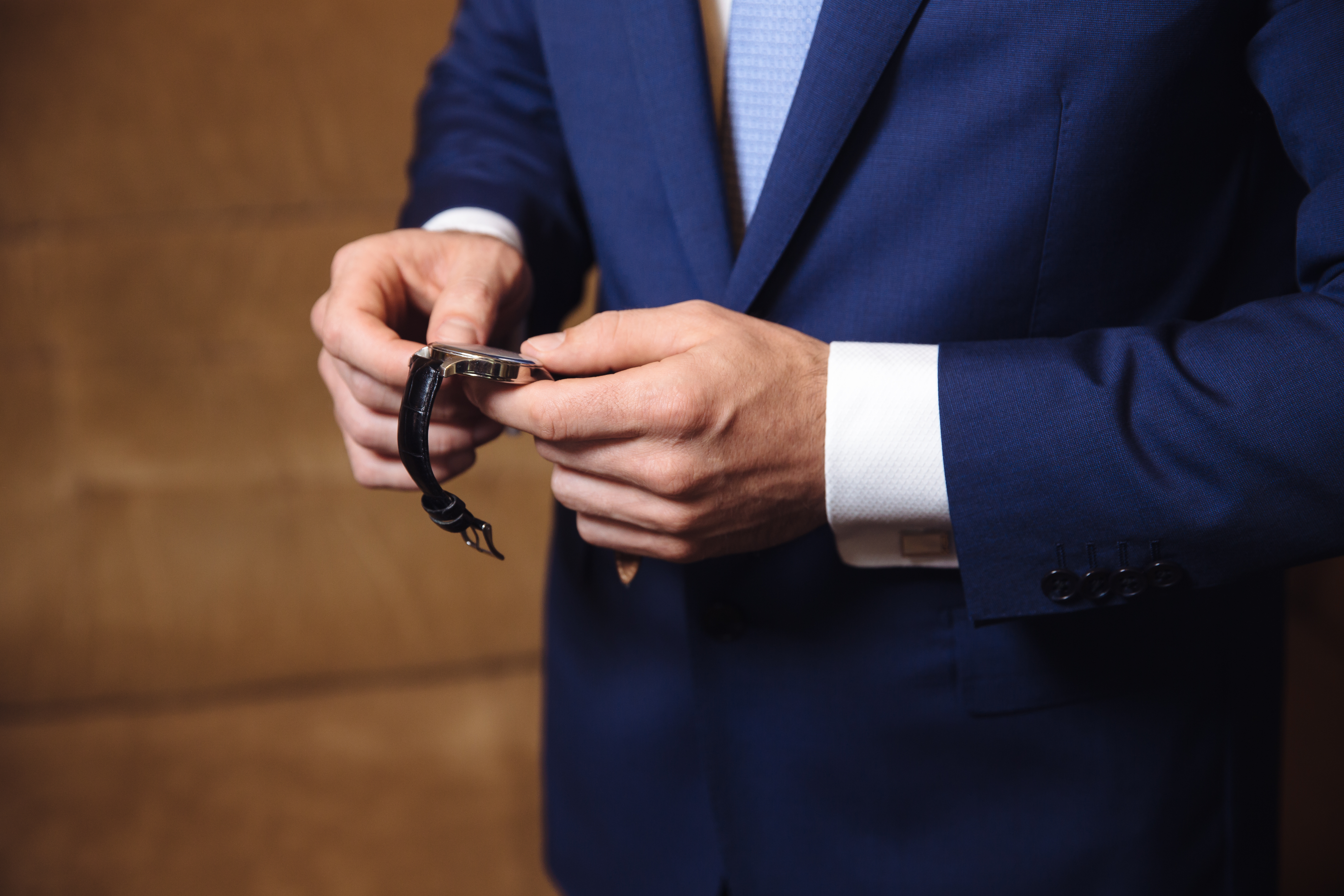 Businessman checking time on his wristwatch. men's hand with a watch.
