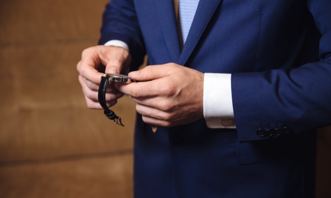 Businessman checking time on his wristwatch. men's hand with a watch.