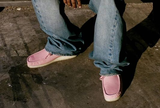 man wearing pink supreme x clarks shoes