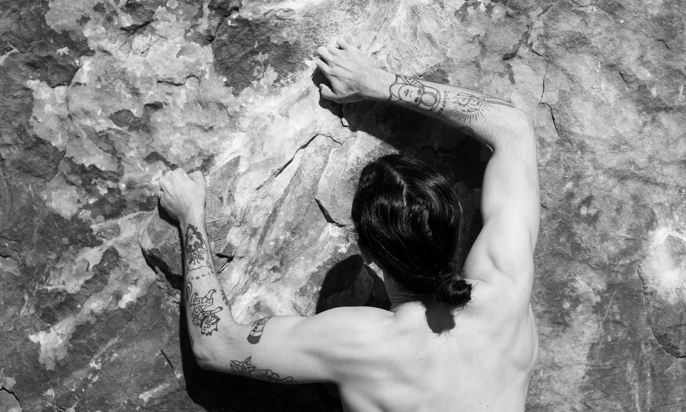 man rock climbing gripping wall