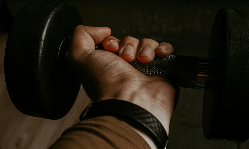 man gripping dumbbell