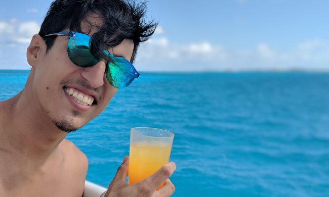 Raul Mercado drinking a cocktail on a boat in Mexico