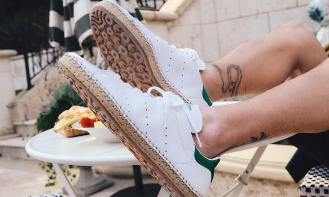 man wearing white adidas stan smith sneakers