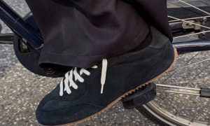 person wearing black axel arigato sneakers