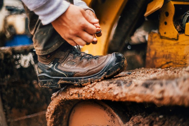 man tying keen boots