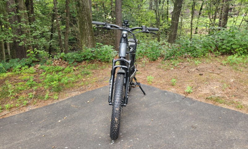 Segway Xafari e-bike front view parked on driveway with trees in the background.