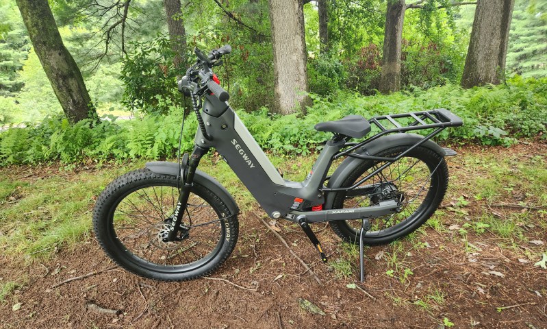 Segway Xafari e-bike left side parked on a grassy hill with trees in the background.