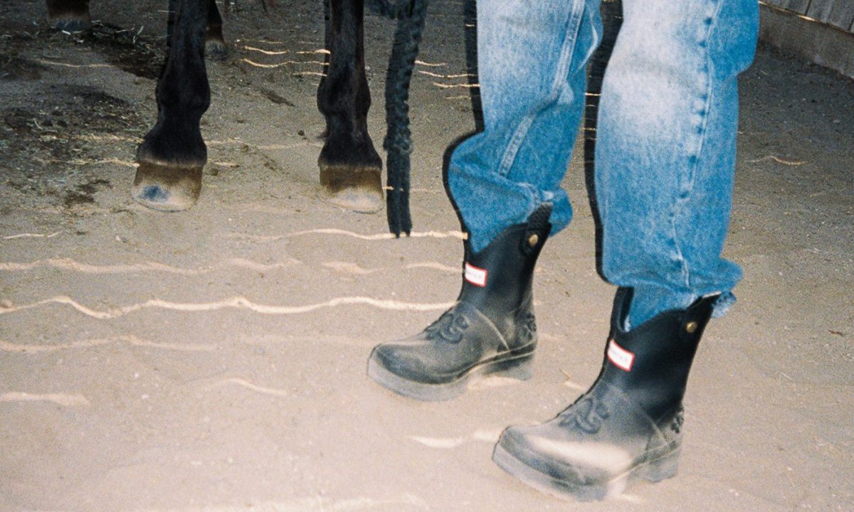 man wearing boots in sand with horse