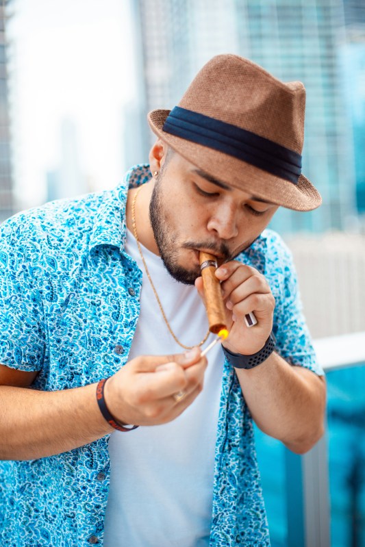 Guy lighting up a cigar