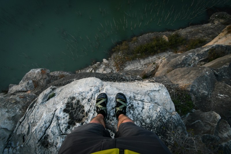 man wearing sandals over edge of cliff