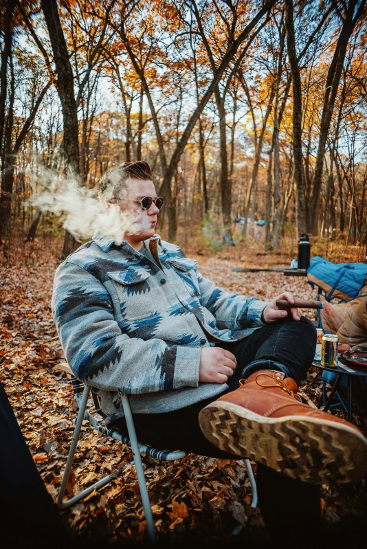 a man sitting in a chair with a cigar in his hand