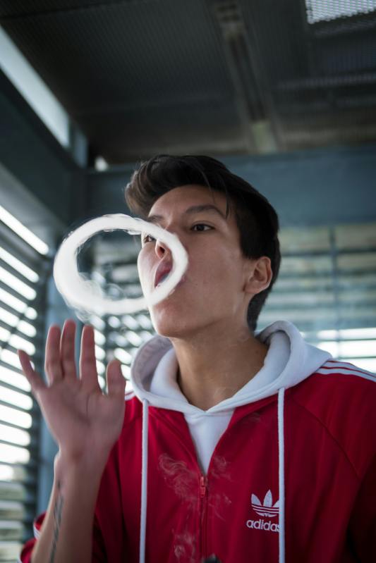 man in red and white hoodie making smoke ring