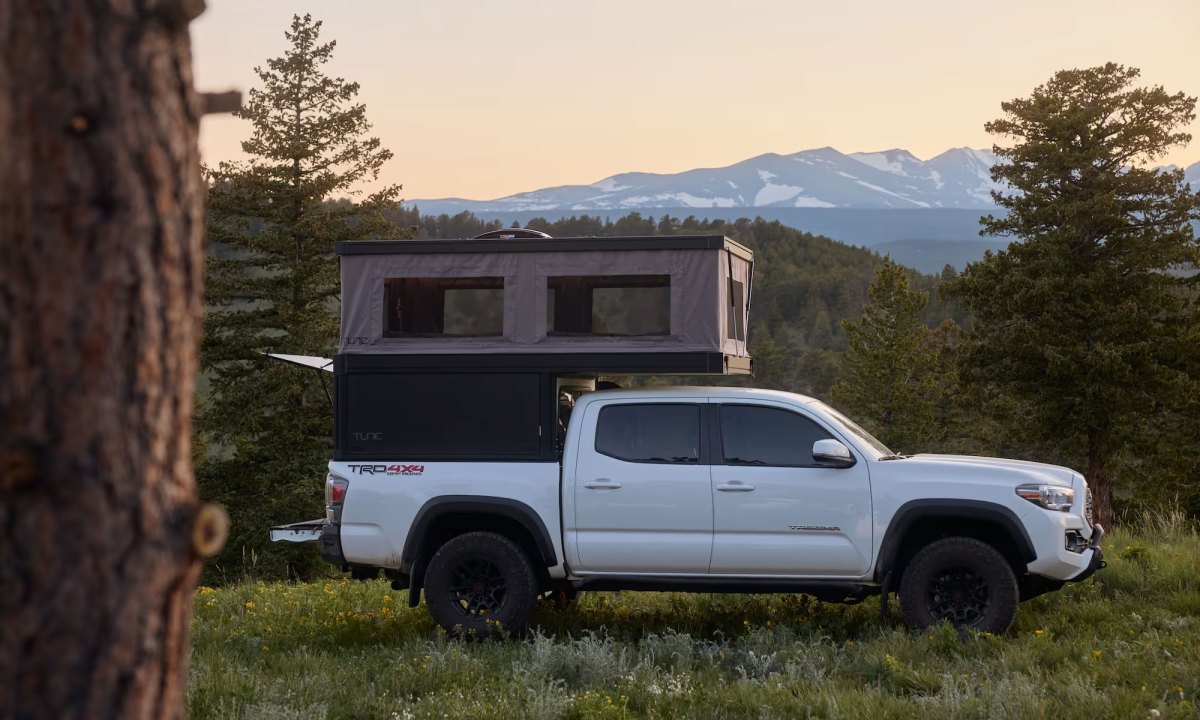 A Tune Outdoor M1 Lite truck camper/topper installed on a white Toyota pickup truck.