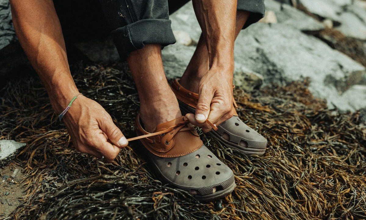 man tying crocs boat shoe