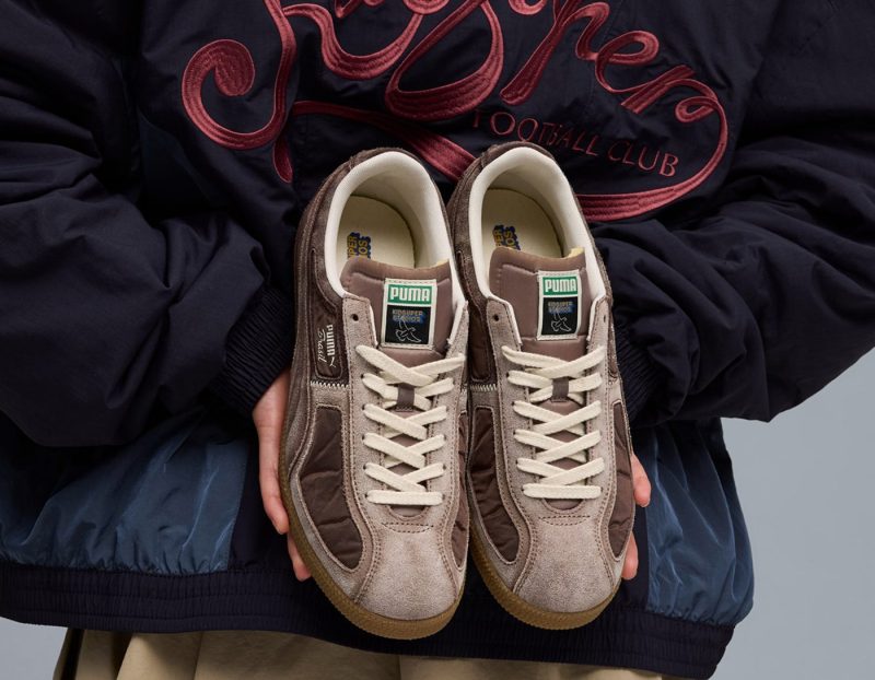 person holding puma sneakers