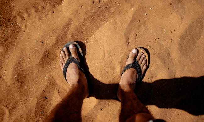 man wearing sandals in sand