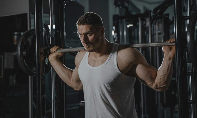 man with barbell squat weightlifting resistance training