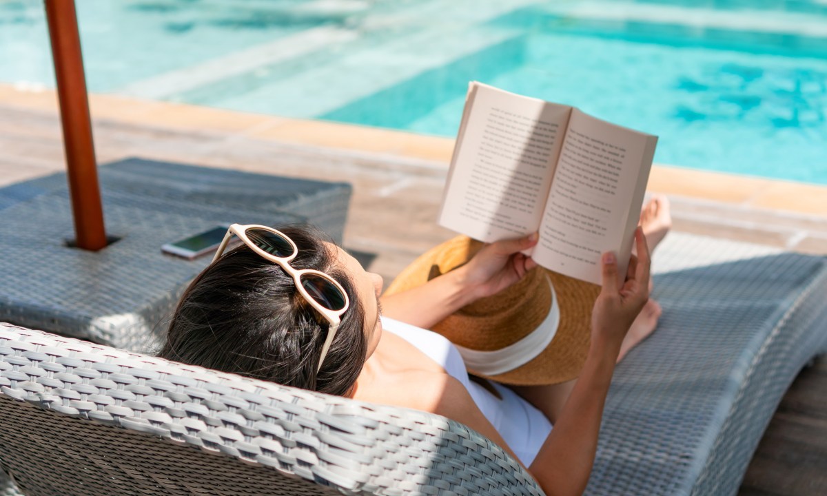 Girl reading a book in a sunbed
