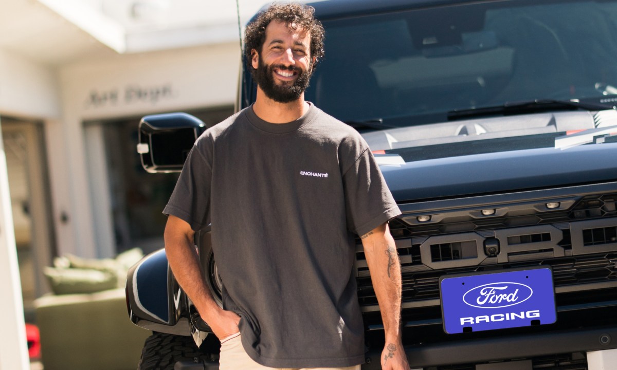 Daniel Ricciardo standing in front of a Ford Raptor smiling.