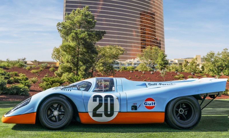 Porsche 917 race car parked on grass with Wynn Las Vegas in the background.