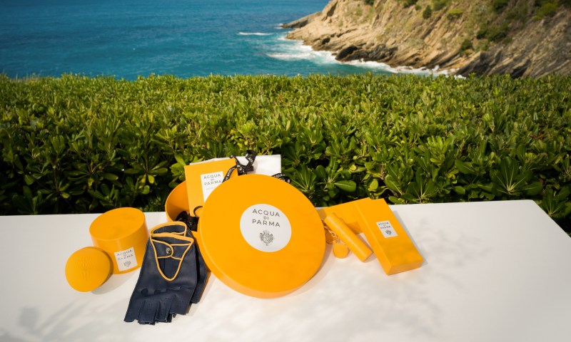 Maserati Acqua di Parma Art of Travel Kit with the sea and cliffs in the background.