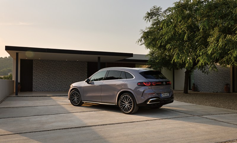 Mercedes-Benz GLS all-electric SUV right rear three quarter view parked by a modern home.