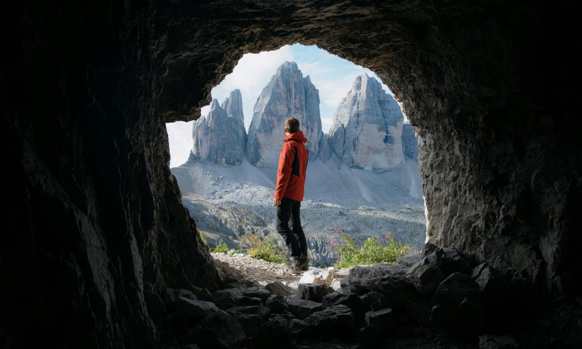 photo looking at a man through the opening of a cave